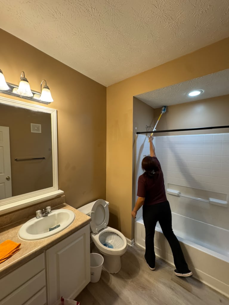 Professional cleaning crew scrubbing bathroom shower