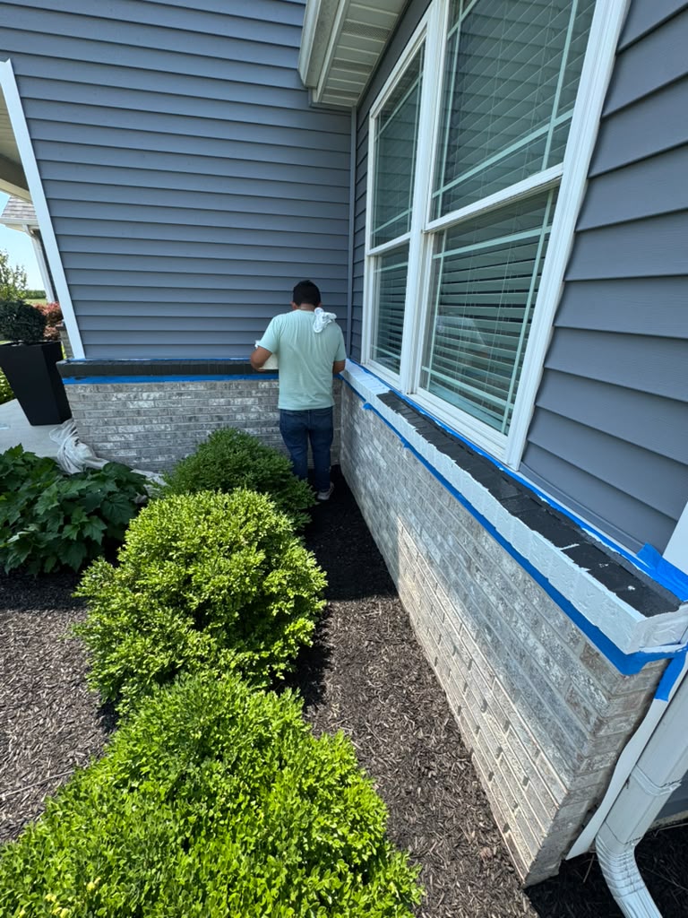 Exterior brick foundation taped for painting